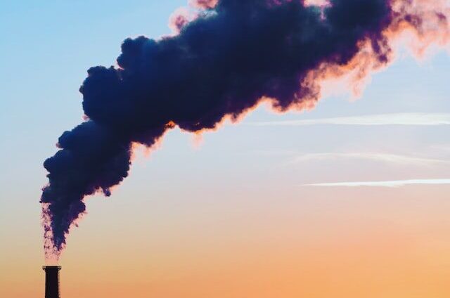 Industrial chimney emitting heavy plume of smoke