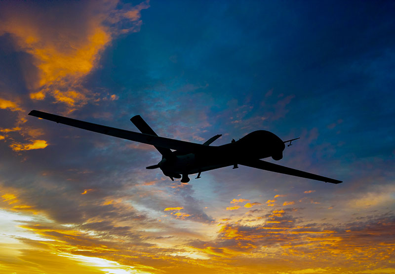 Image of drone flying with sunset behind
